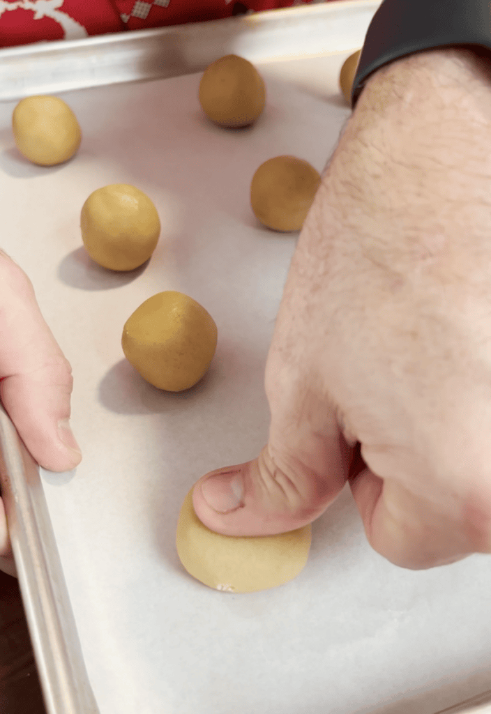 Pressing cookie dough balls.