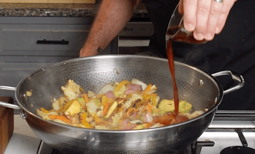Sauce pouring over vegetables.