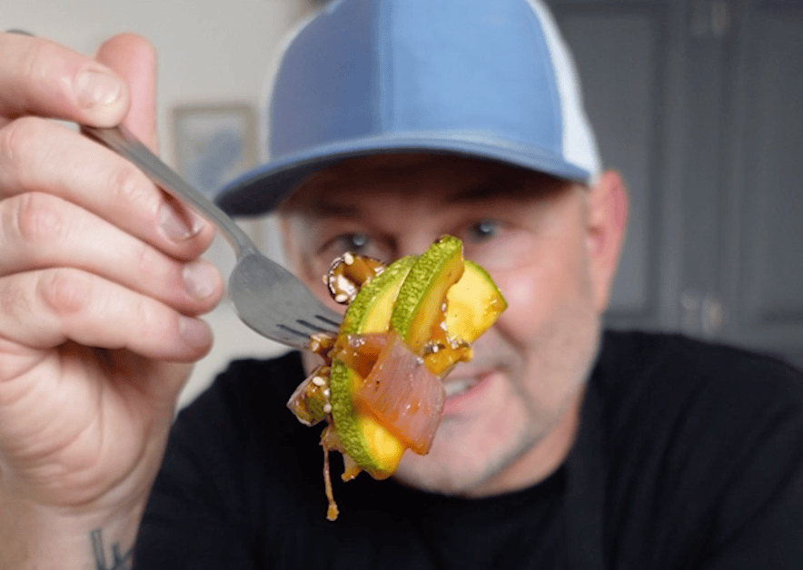 Fork holding sautéed vegetables.