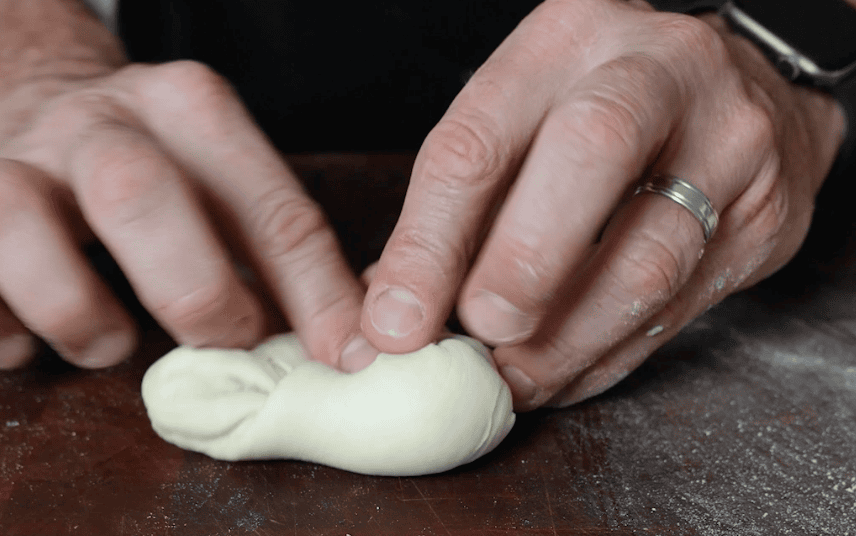 Folding dough into a ball.