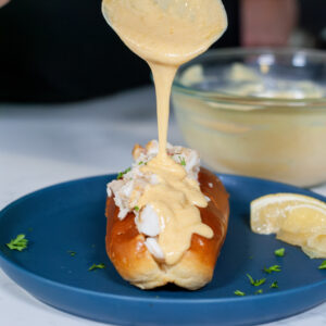 Beurre Blanc Sauce pouring over a lobster roll.