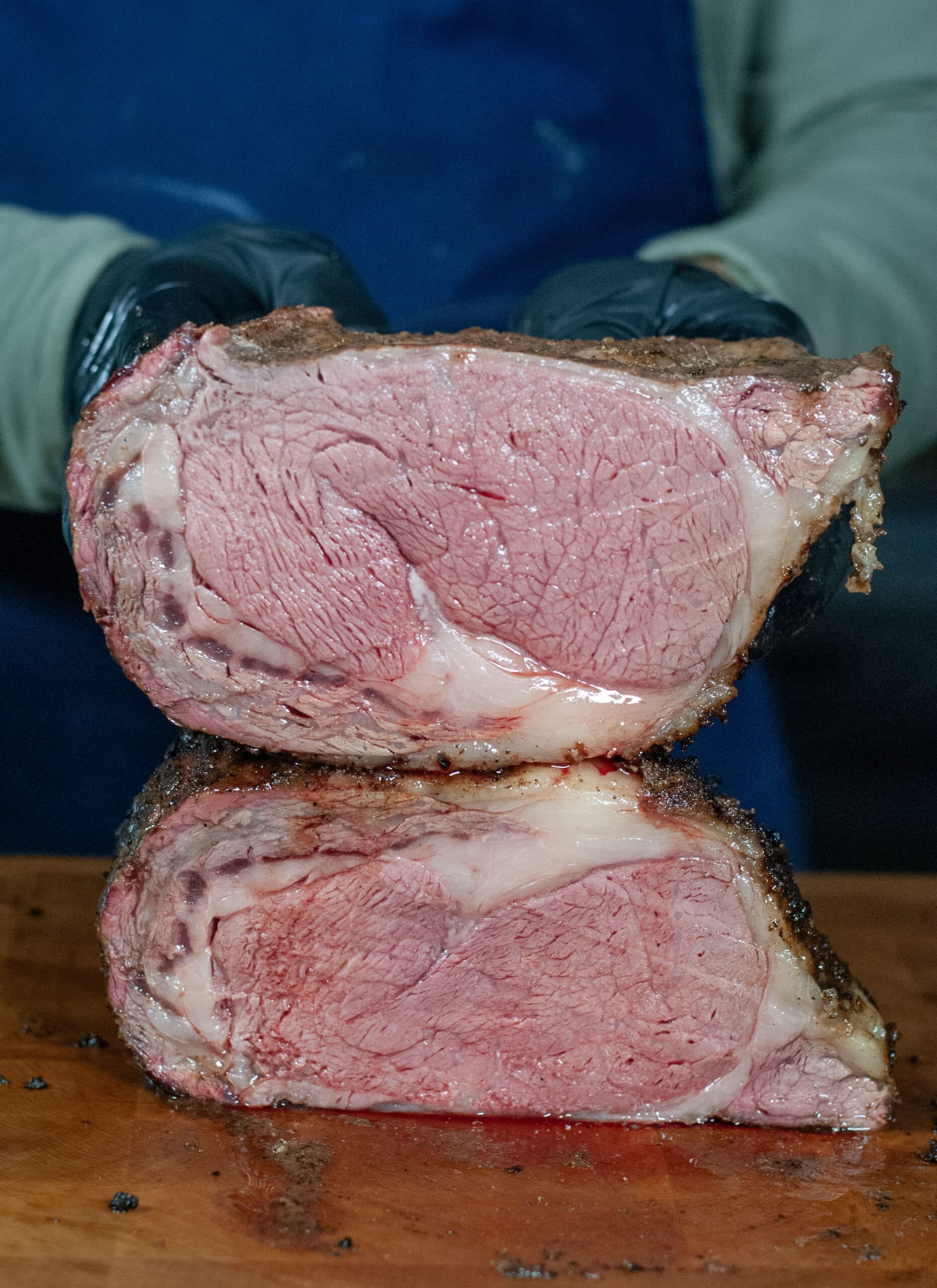 A prime rib cut in half showing a medium rare cook.