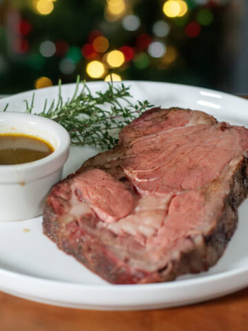 A slice of prime rib next to au jus.