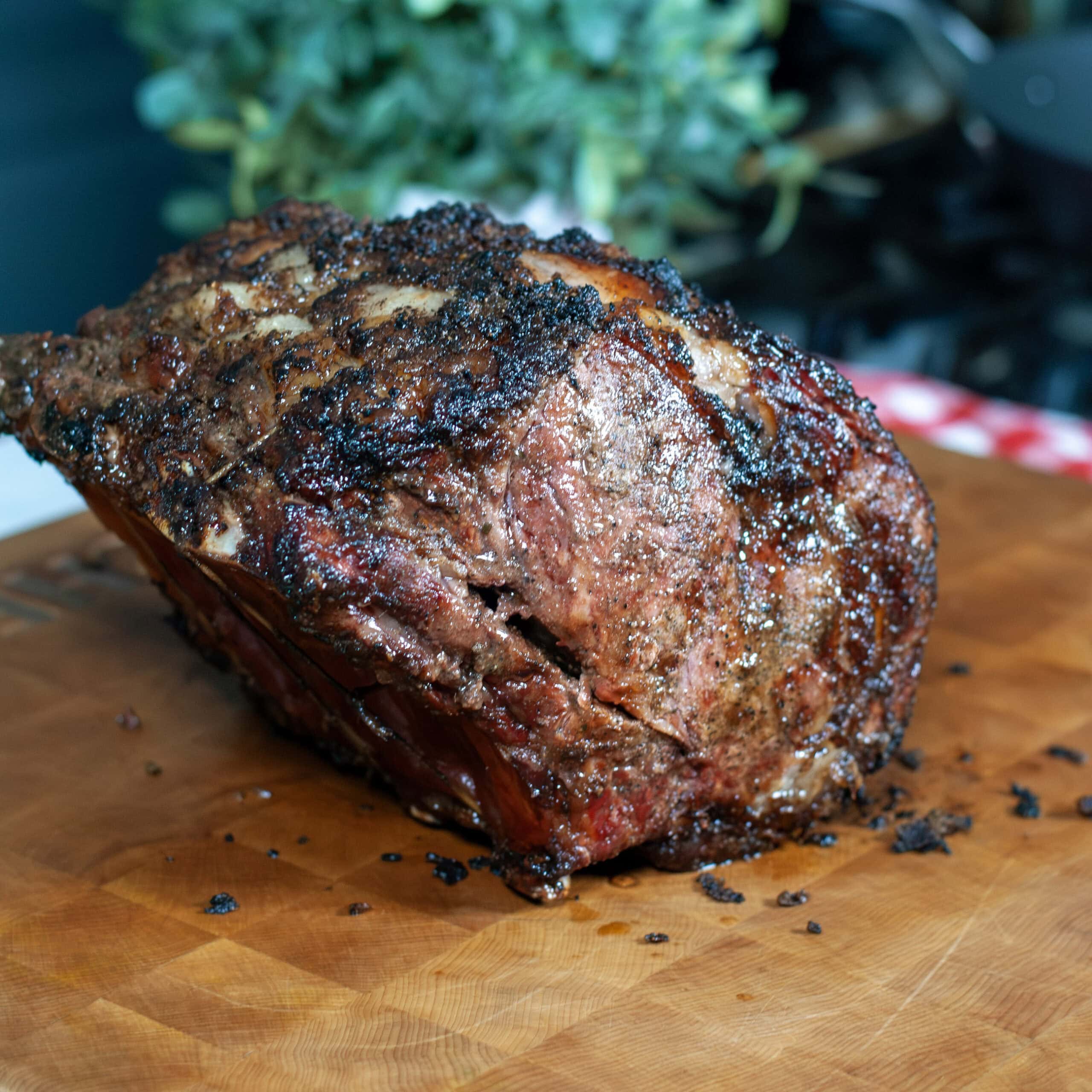 A whole cooked prime rib with a crusted outside.