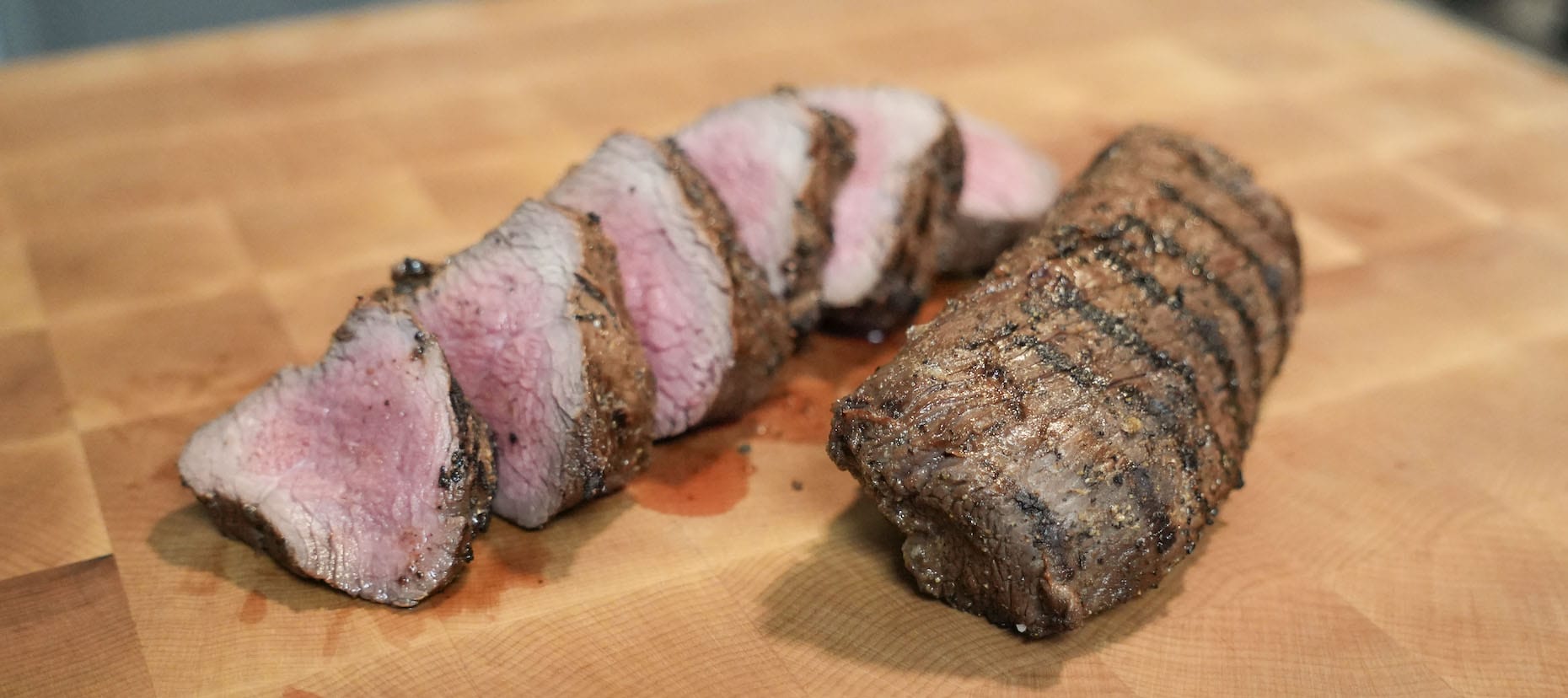 Venison backstrap on cutting board.