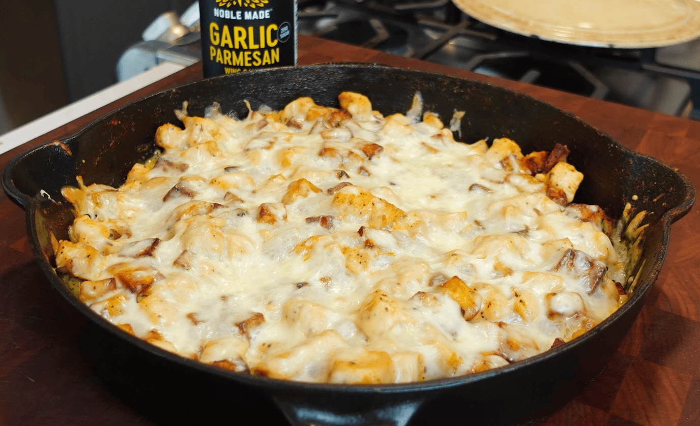 Chicken and cheese in a skillet.