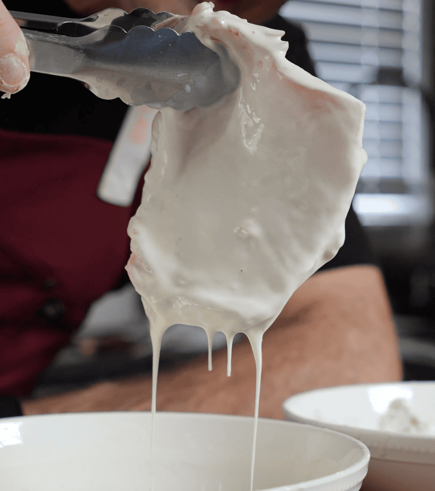 Chicken coming out of egg wash.