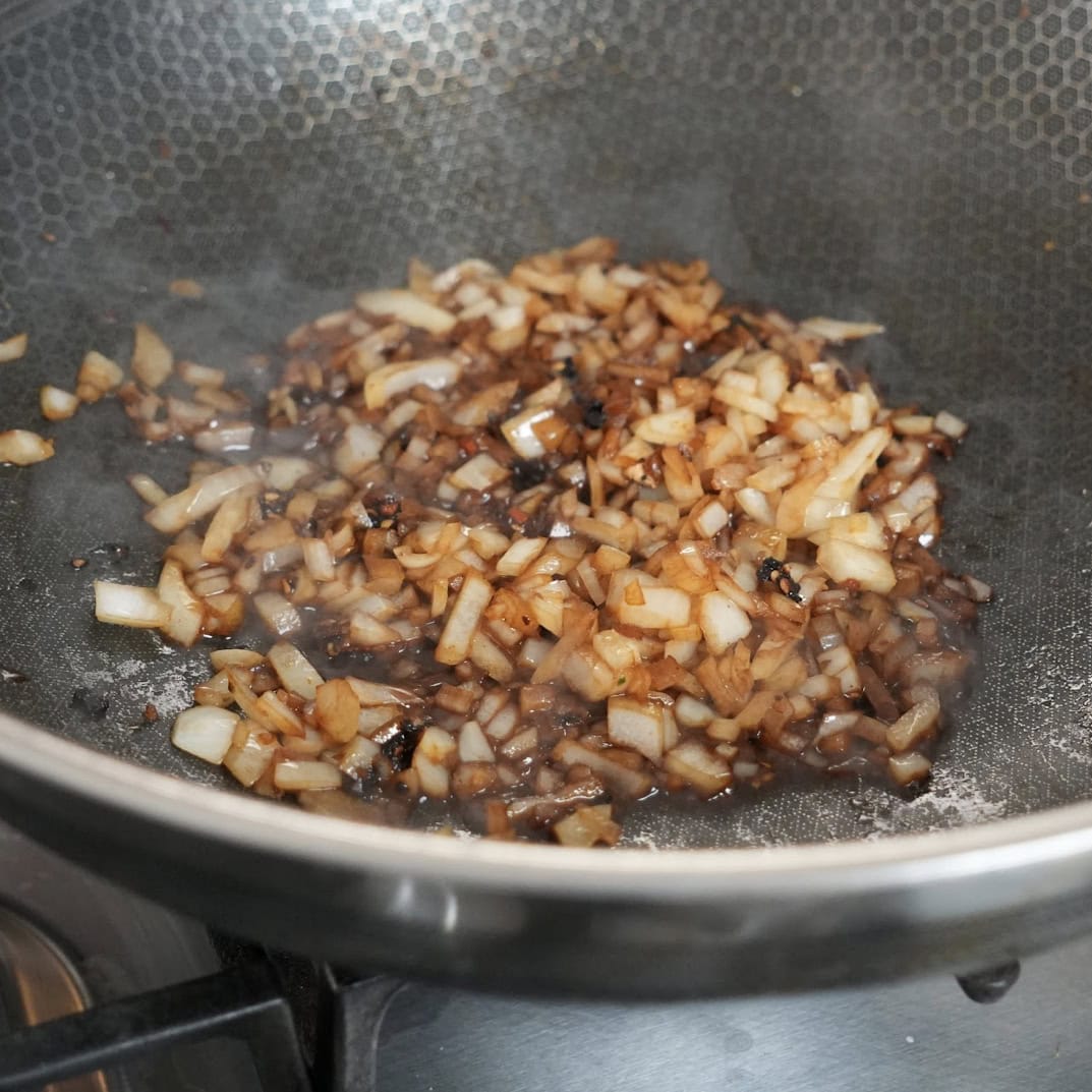 Onions cooking in a wok.