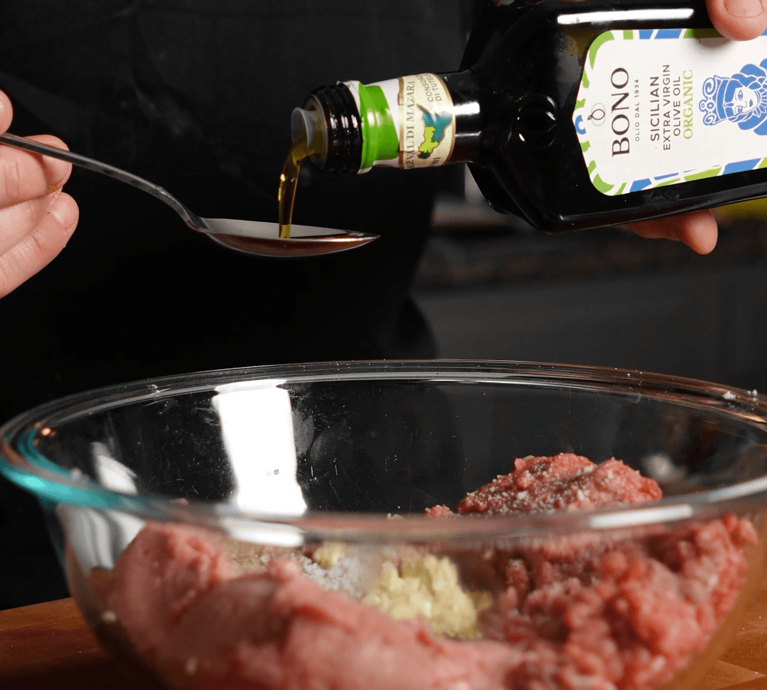 Olive oil going onto a spoon.