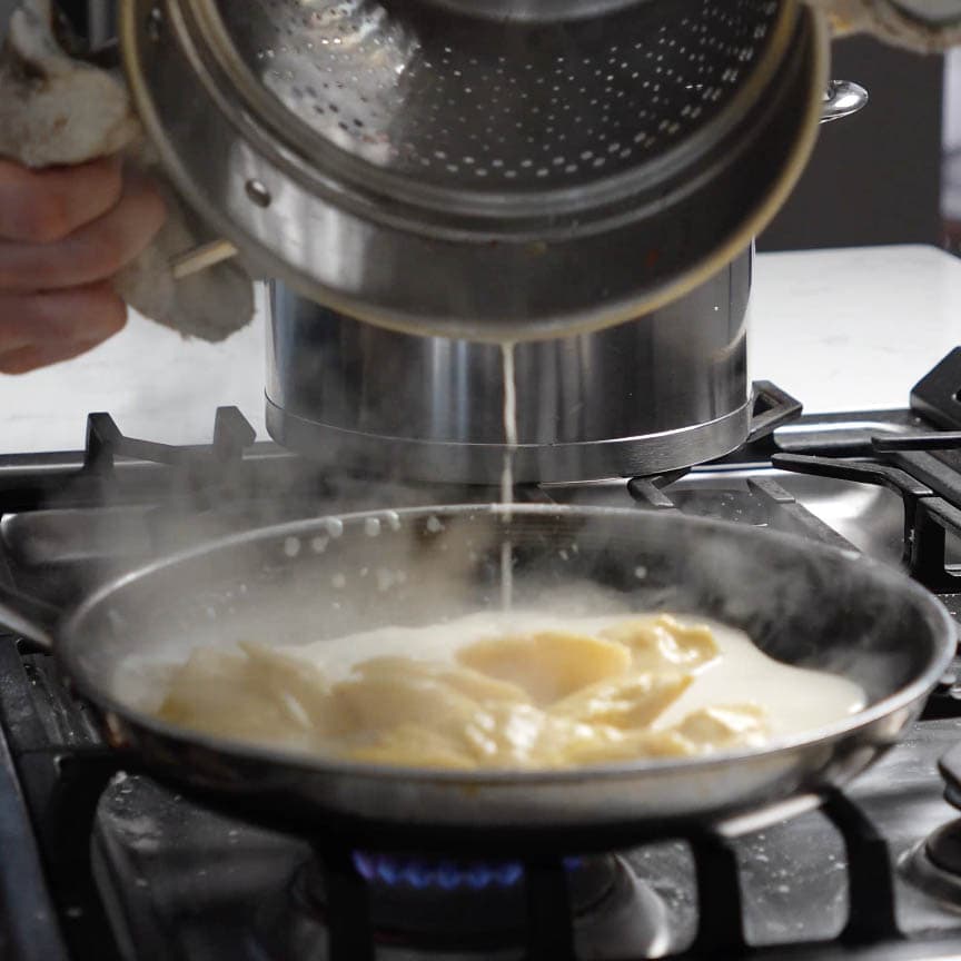 Ravioli cooking in a pot.