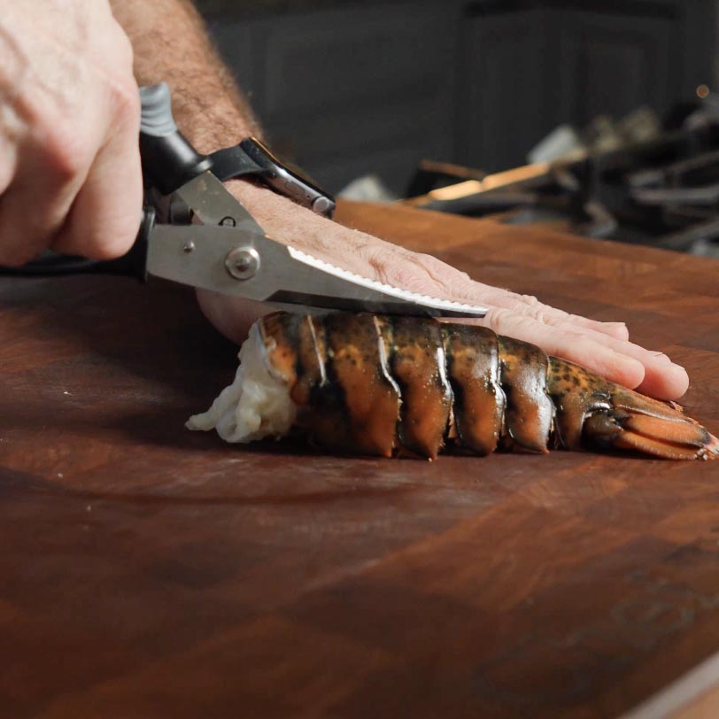 Cutting into a lobster tail.