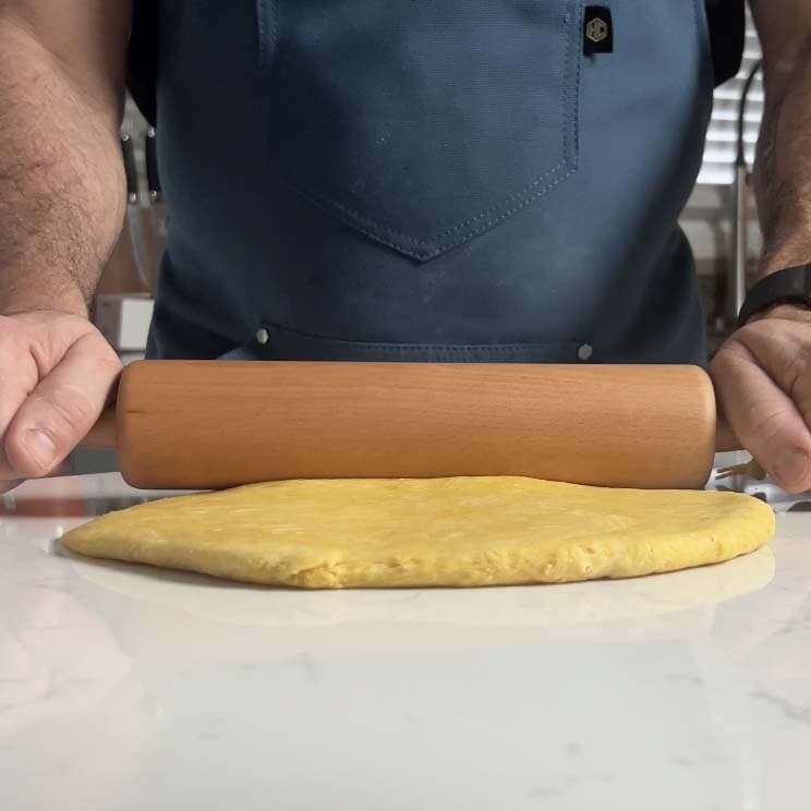 Rolling pasta with a rolling pin.