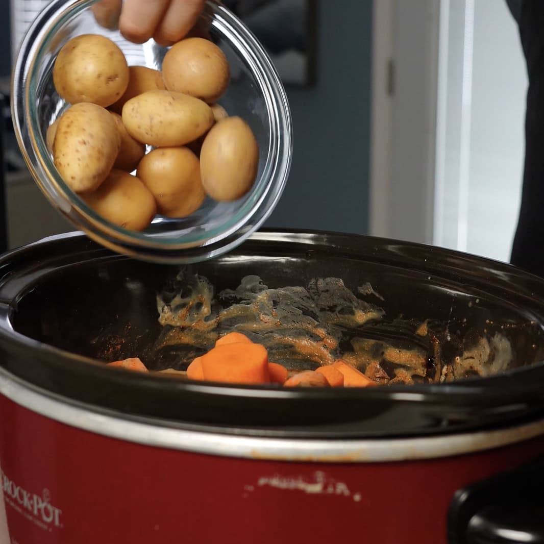 Potatoes going into a crockpot.