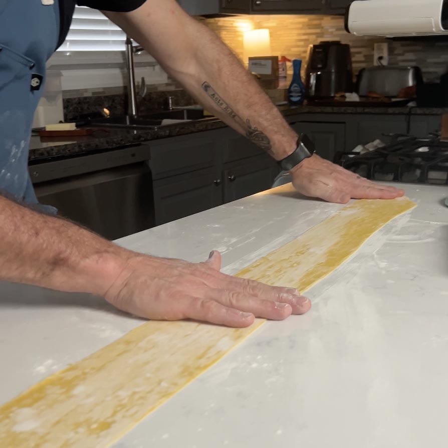 Laying out a sheet of pasta for filling ravioli.