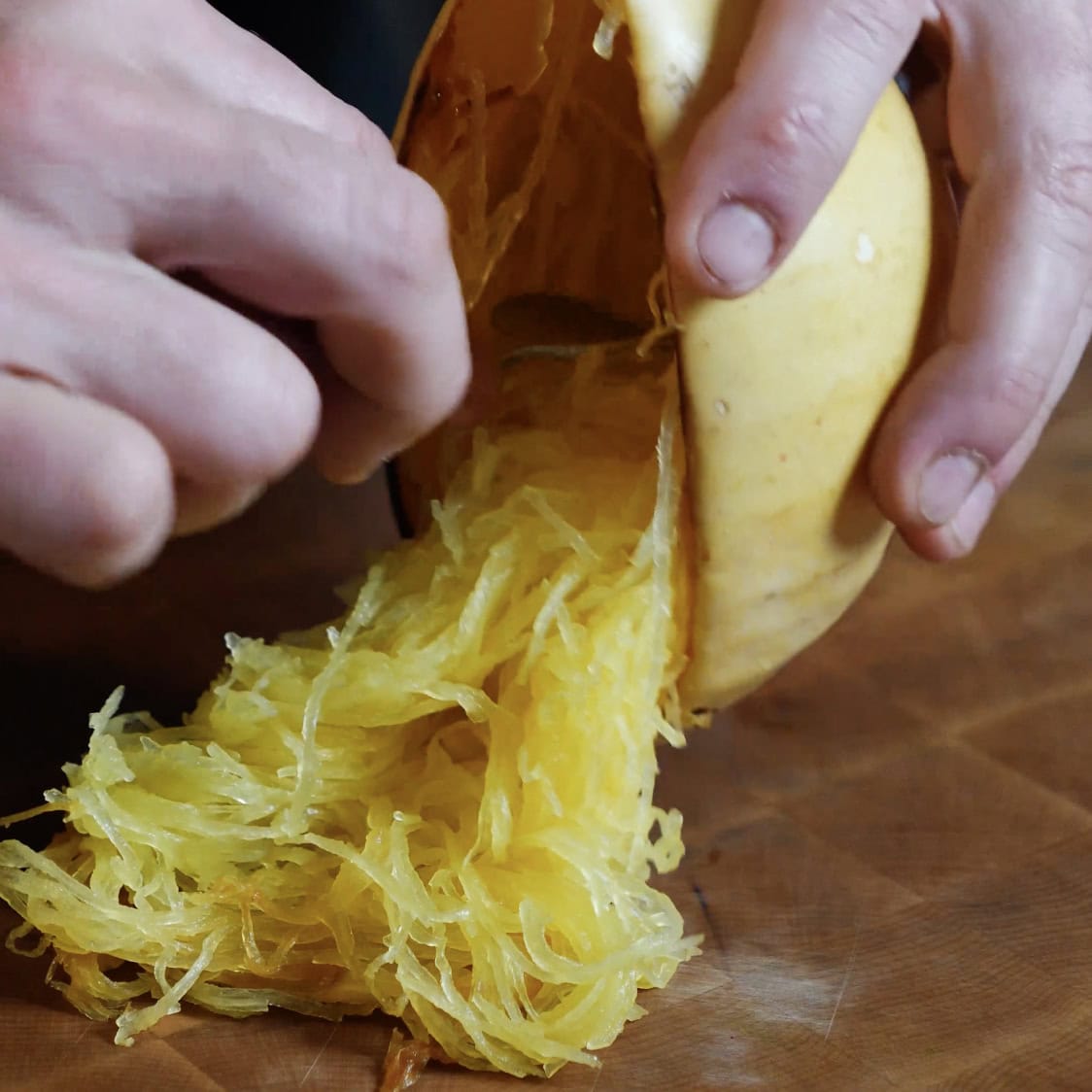 Spaghetti Squash being pulled out of squash.