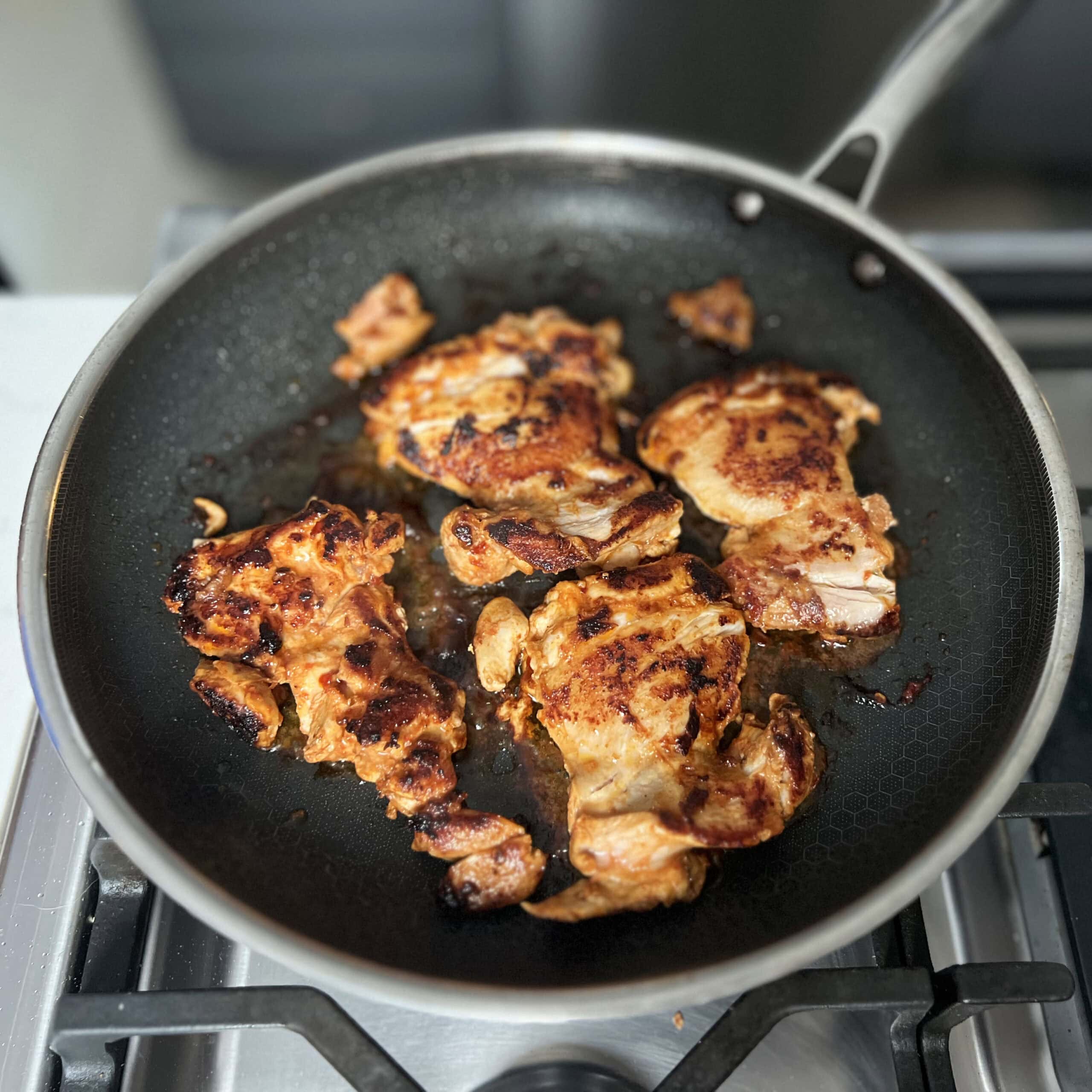 Cooked chicken in a skillet ready to chop and get ready to assemble.  