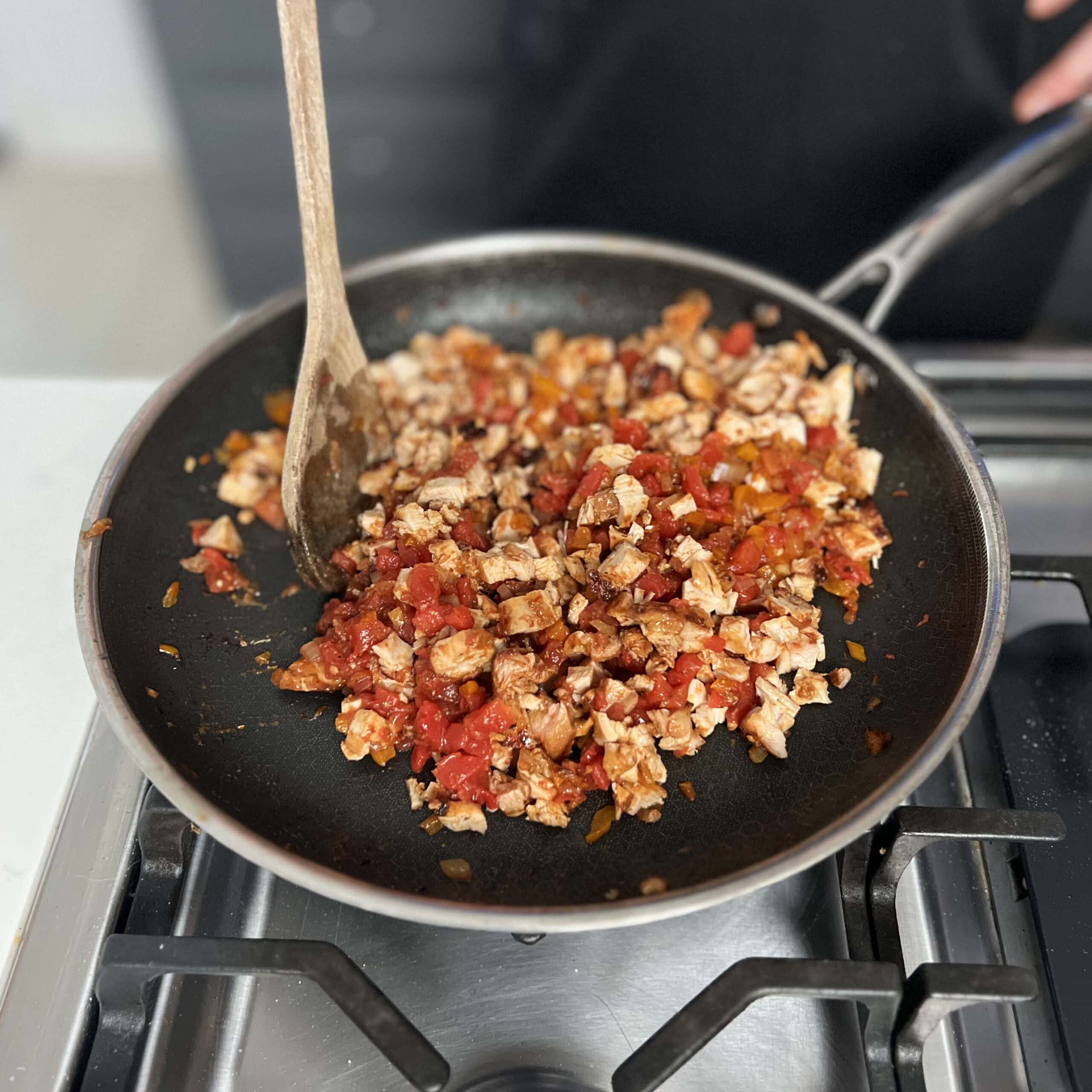 Vegetables and chicken all prepped in a skillet.  