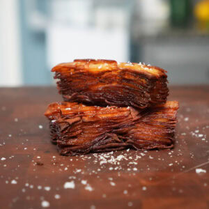 Fried potato stack on a cutting board with salt.
