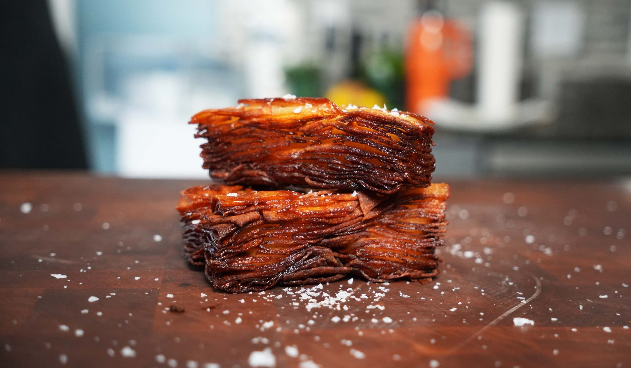 Potato stacks on a cutting board with salt.