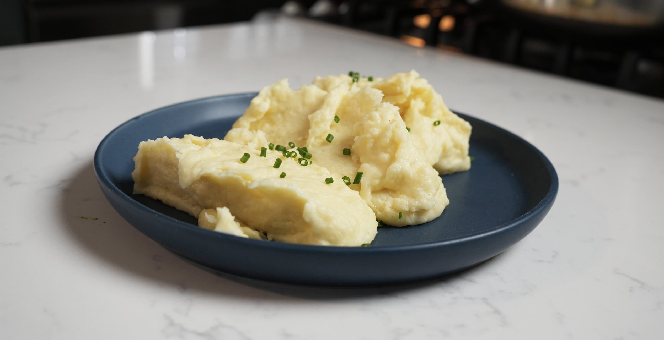 Mashed Potatoes on a plate with chives.