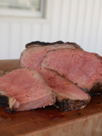 Sliced New York Strip Loin Roast on a cutting board.