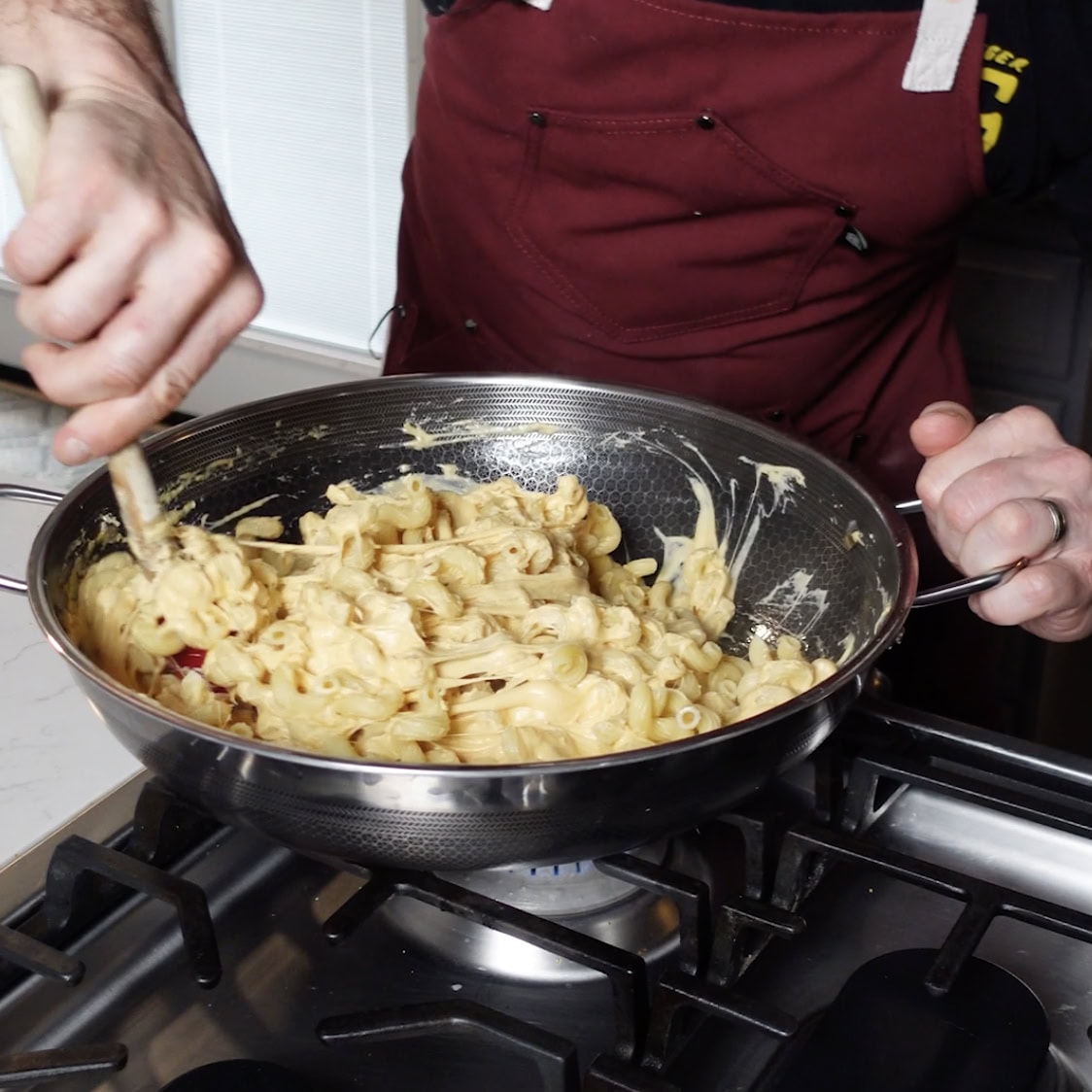 Stirring Mac and cheese in a skillet.