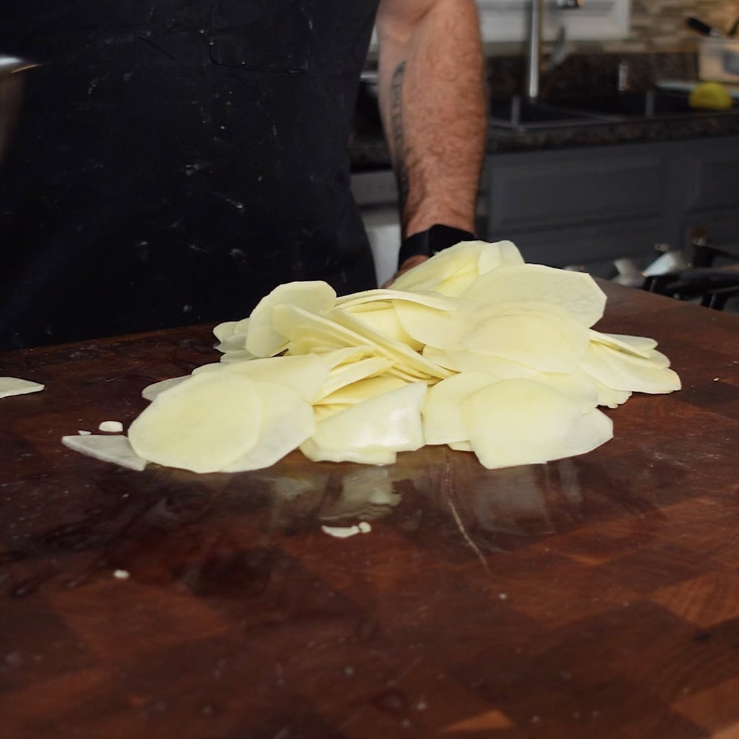 Sliced potatoes on a cutting board.