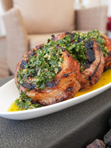Pork Loin Pinwheels with Chimichurri on a white plate.