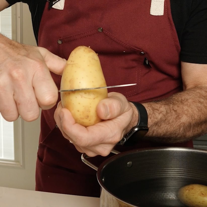 Cutting a potato in half.