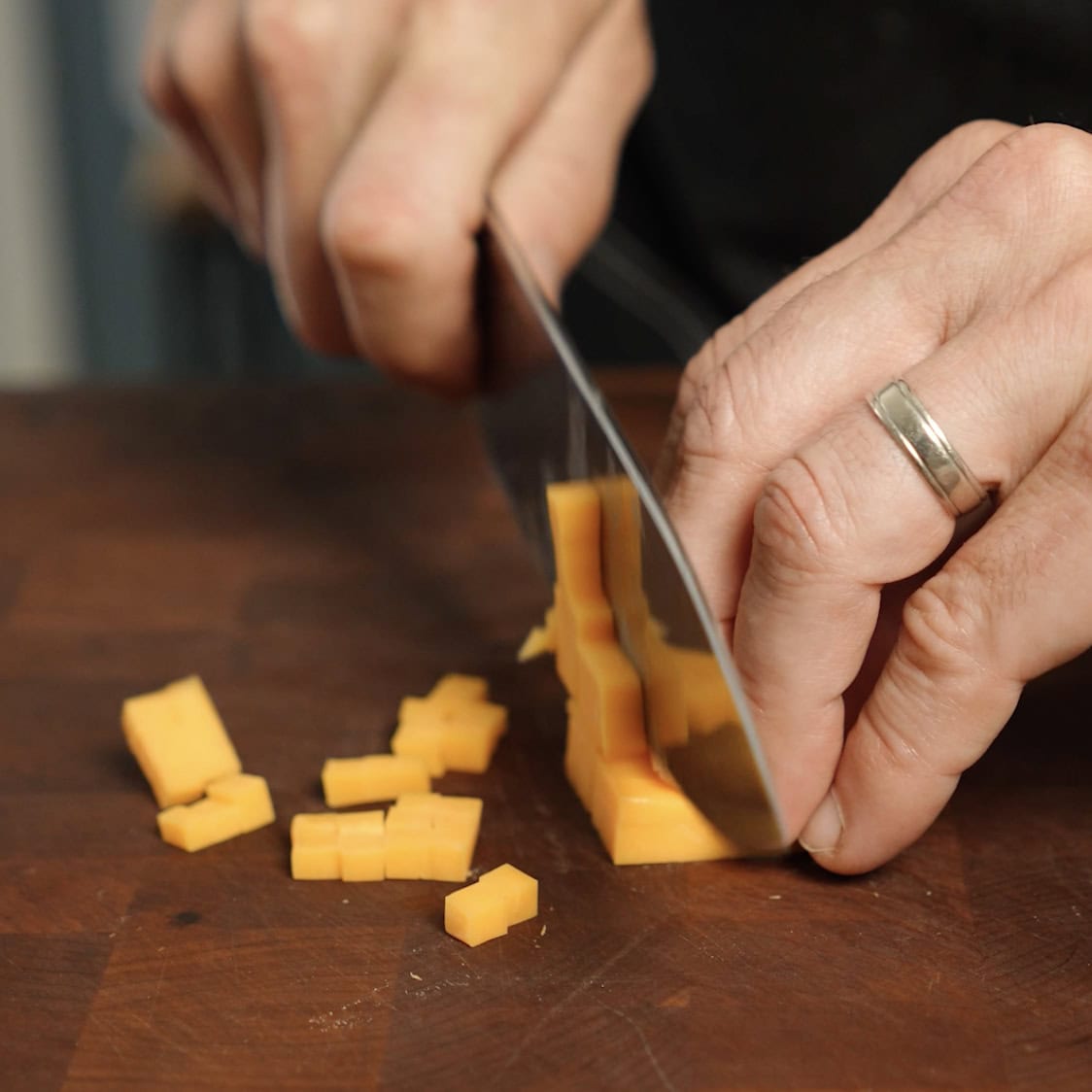 Cutting cheese into cubes.