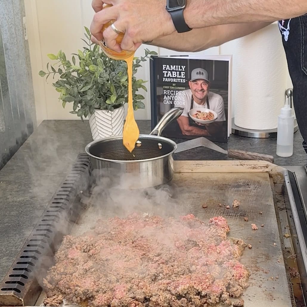 Browning taco meat on the griddle next to nacho cheese.
