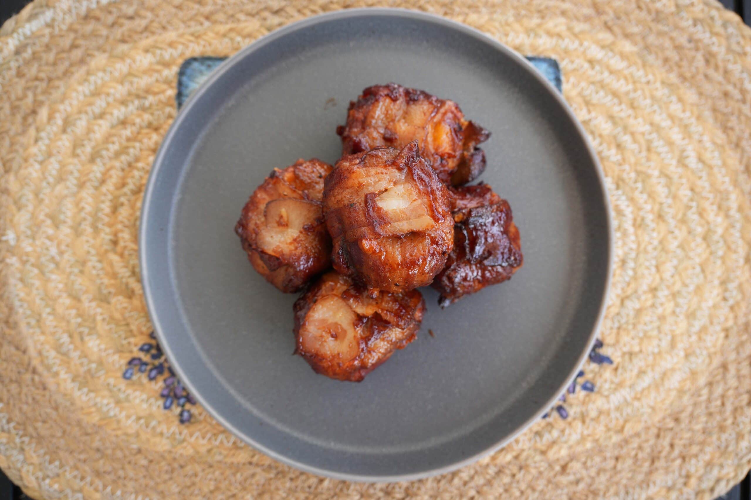 Finished chicken thighs on a grey plate.