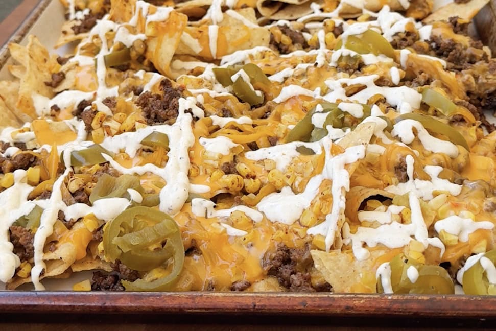Nachos topped with cheese jalapeño and cilantro lime sauce.