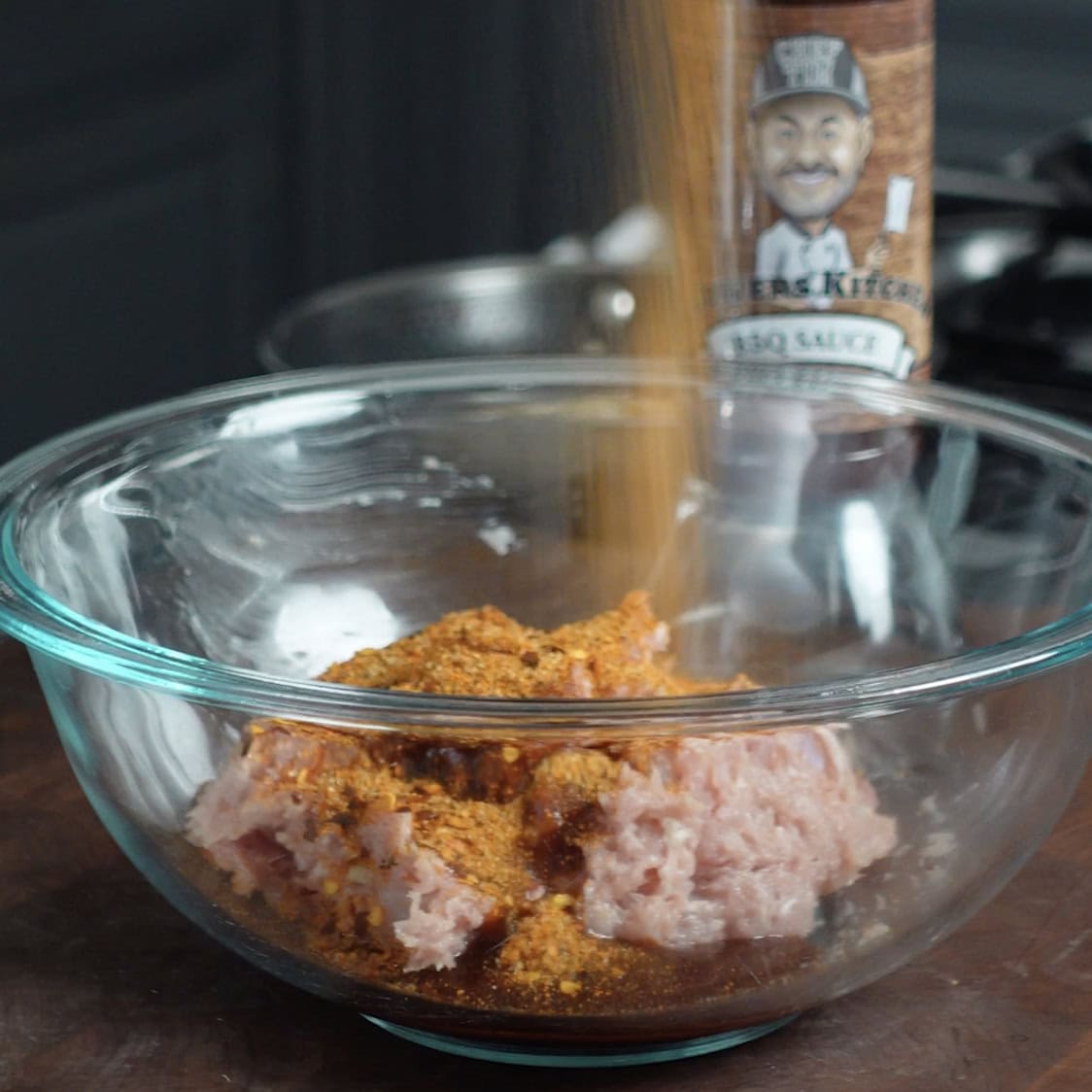 Seansoning chicken thighs to make meatballs.