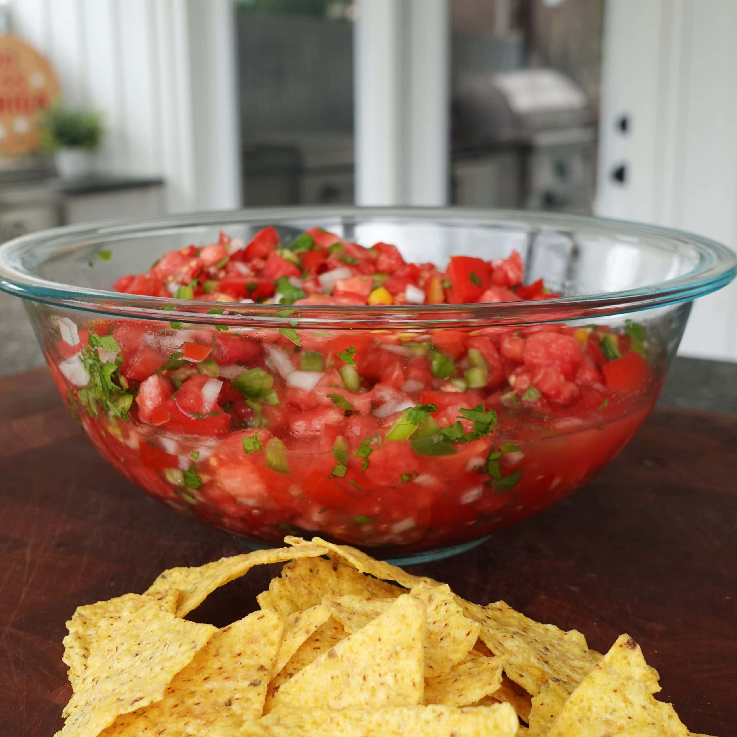 Three Pepper Salsa in a bowl with tortilla chips.