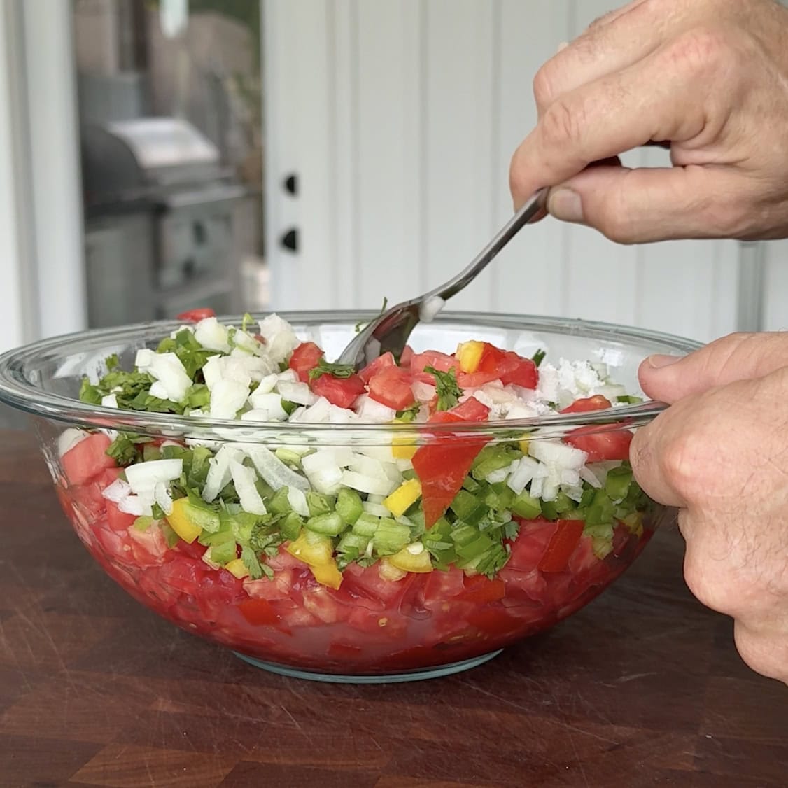 Mixing up salsa with a spoon.