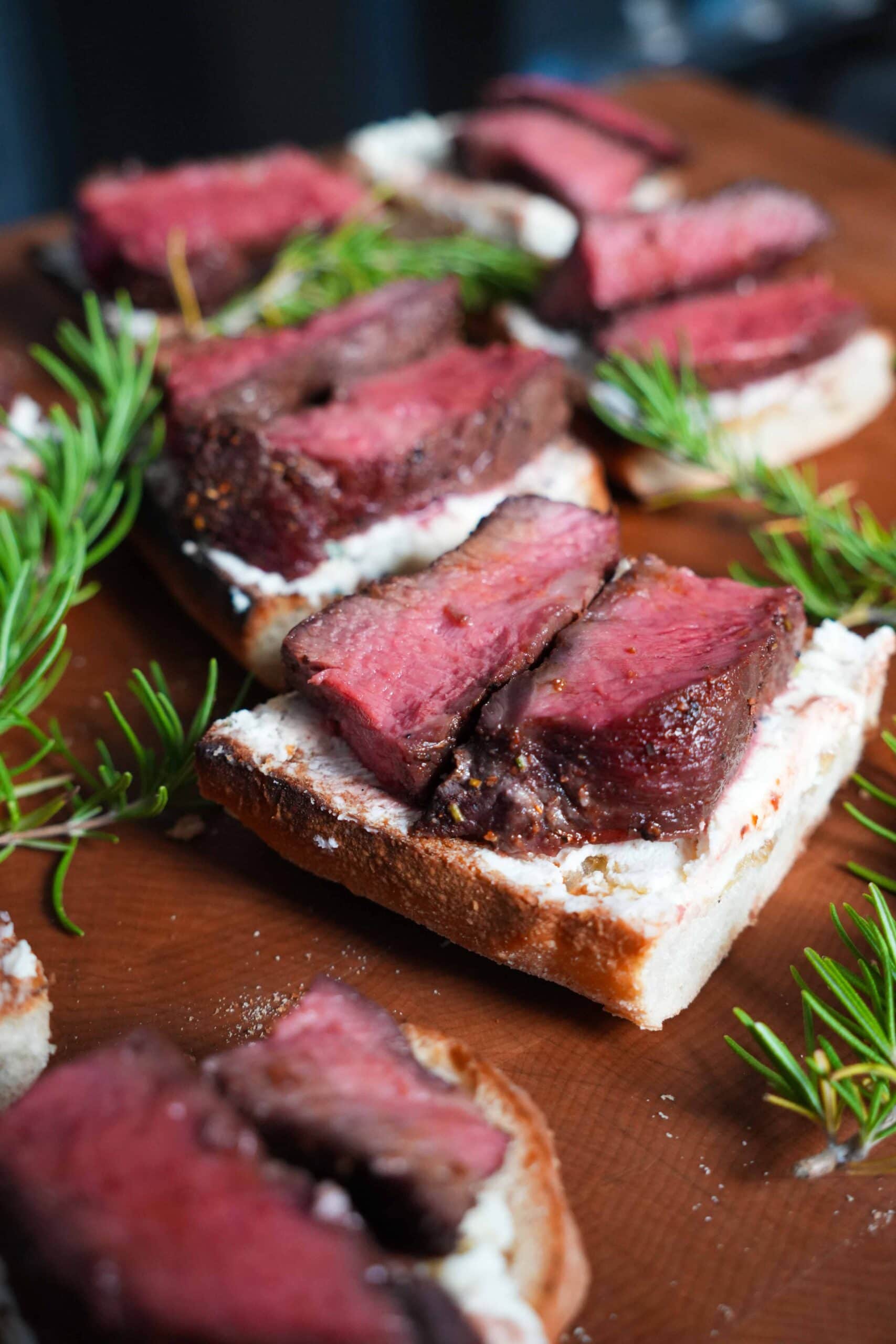 Steak crostinis on a cutting board.
