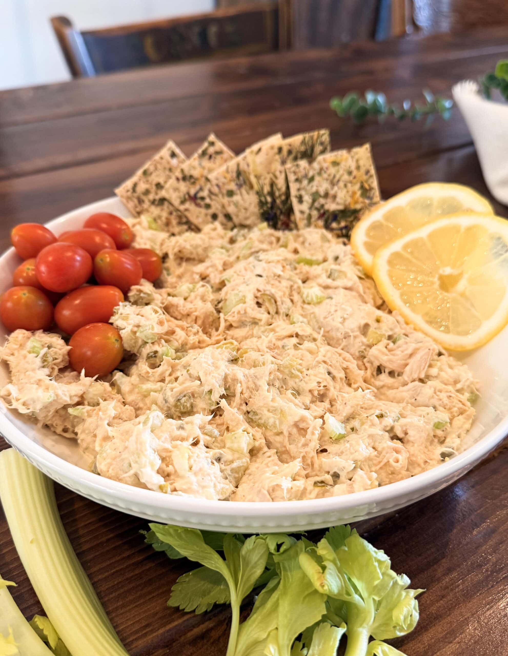 Chicken Salad on a plate with celery, crackers and lemon.