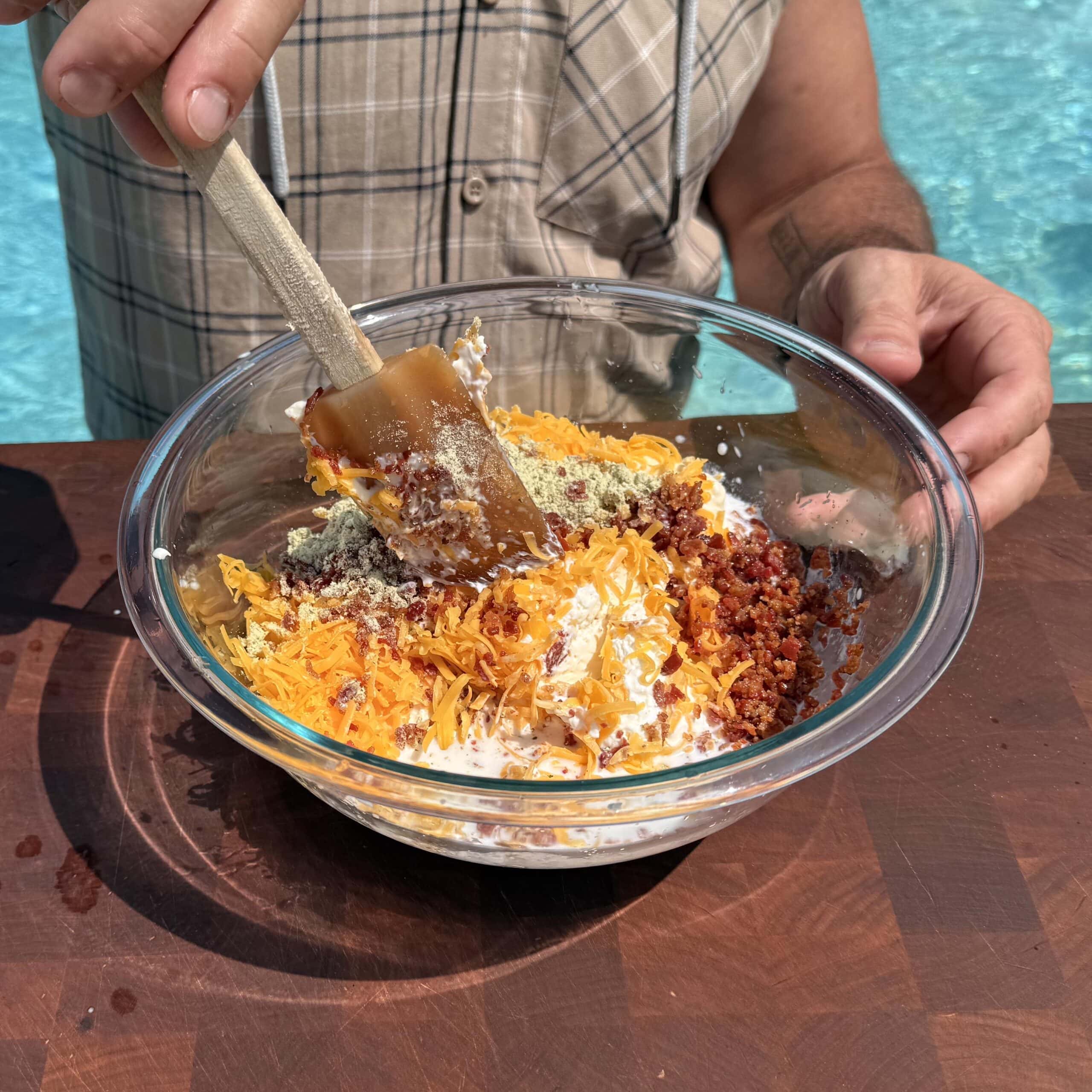 Mixing bacon ranch dip in a bowl.