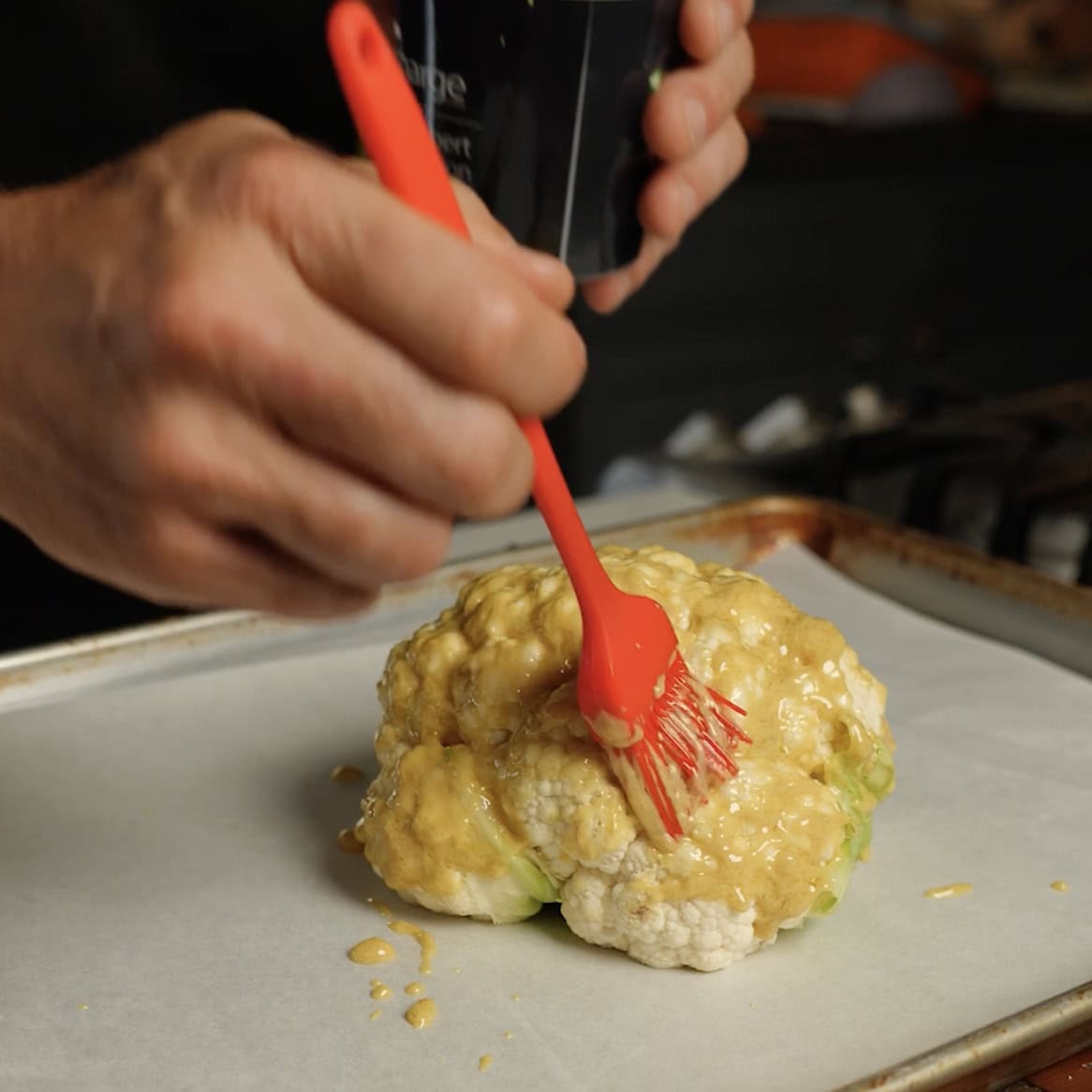 Brushing Cauliflower with mustard.