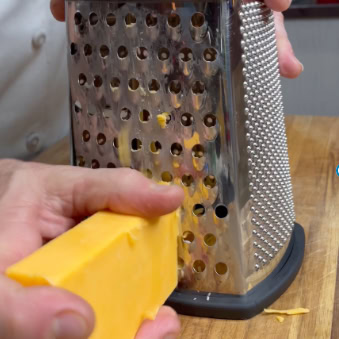 Shredding cheese with grater.