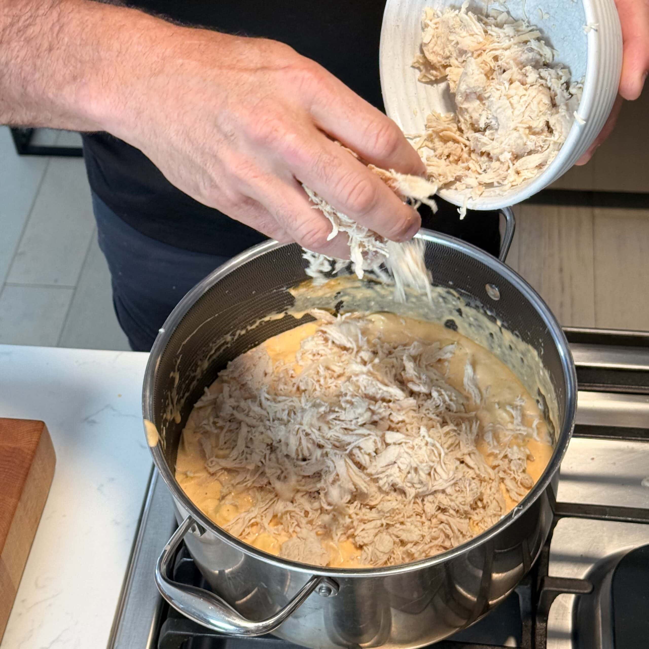 Shredded chicken in a stock pot.