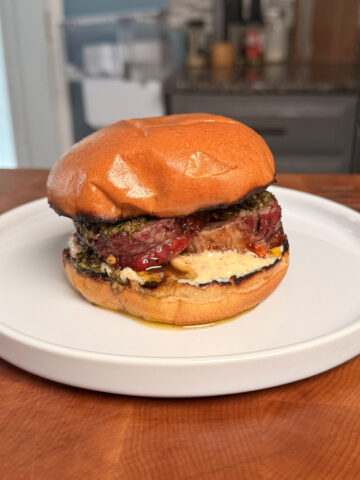 A steak burger on a plate.