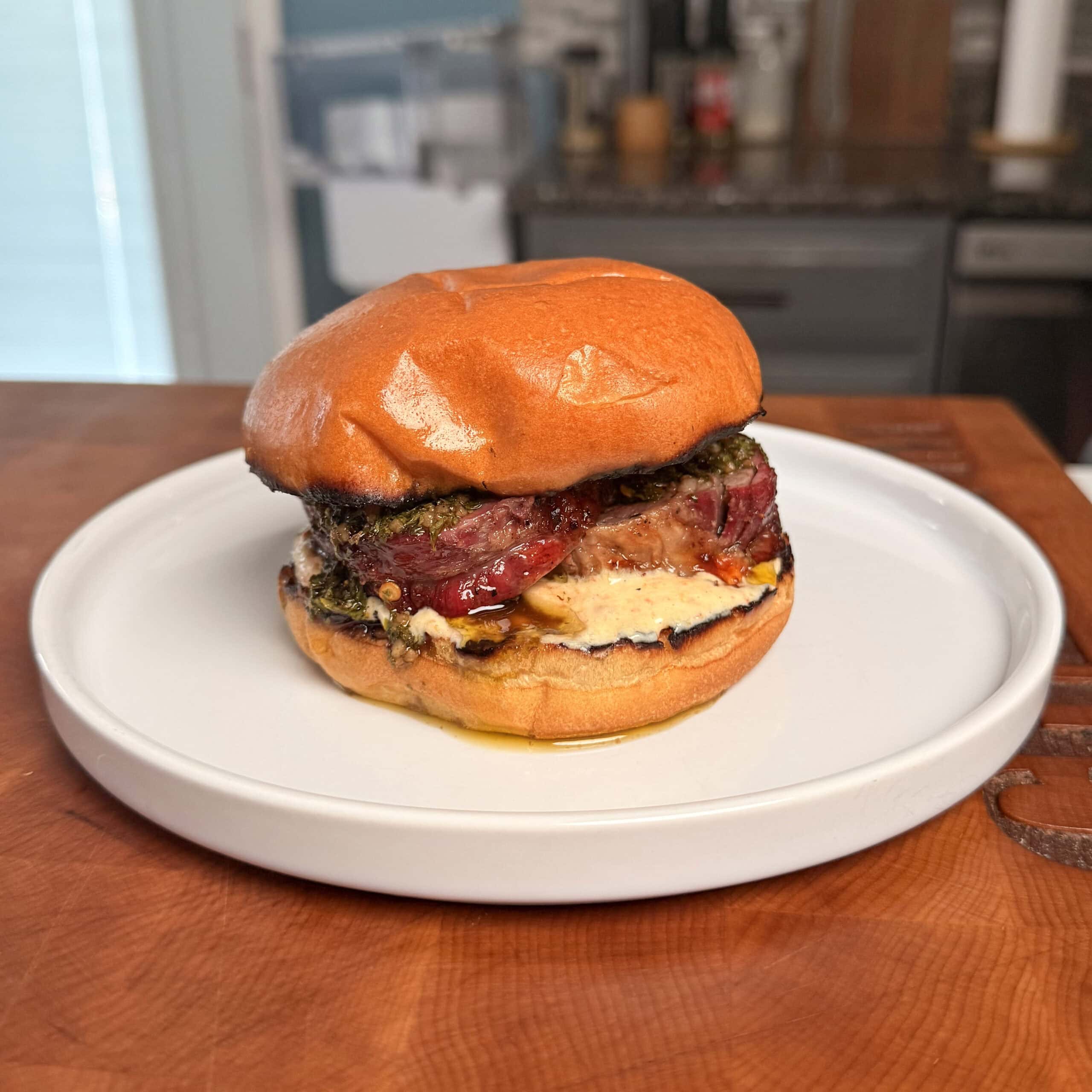 A steak burger on a plate.