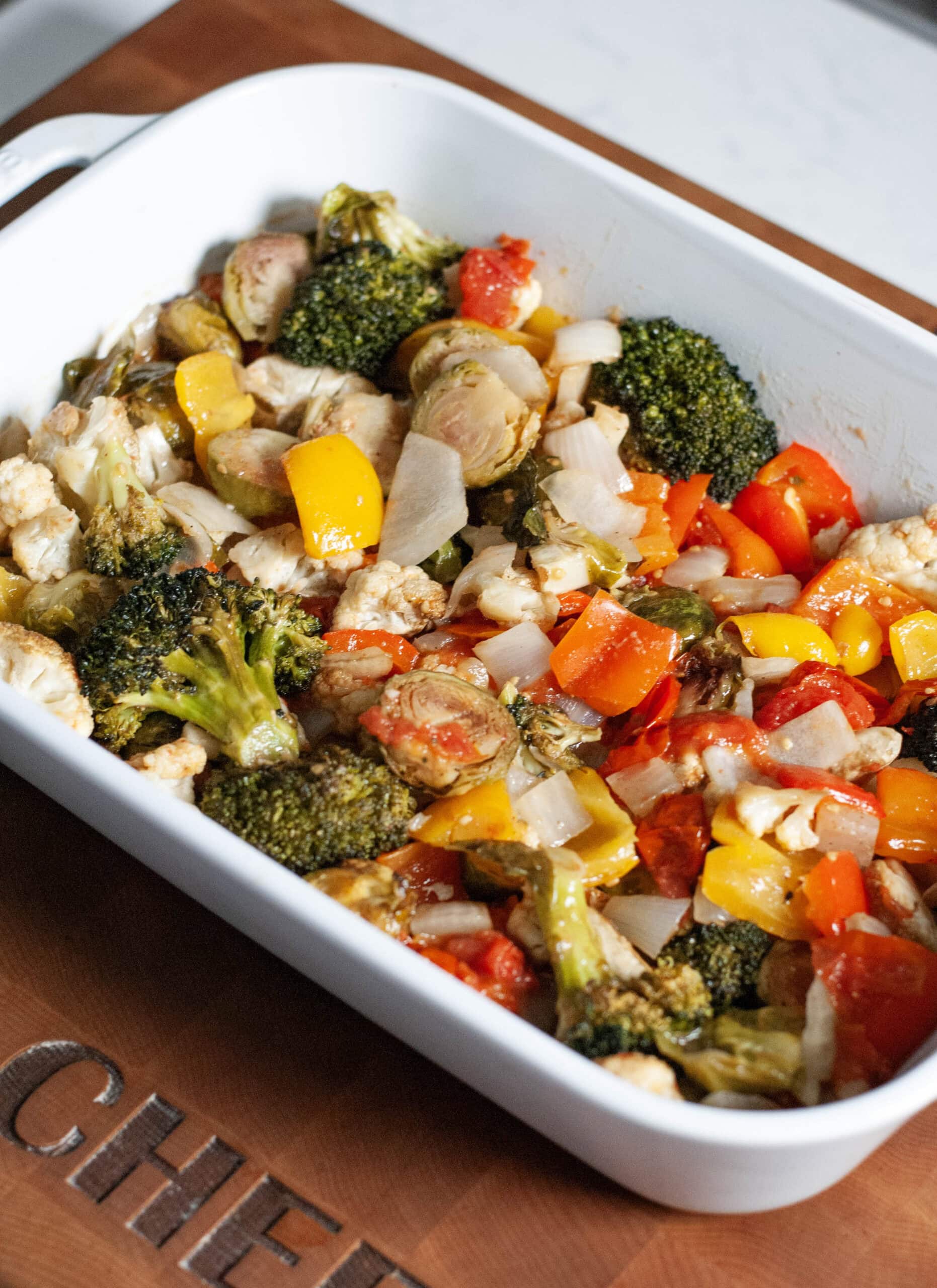 Roasted broccoli peppers and onions in a baking dish.