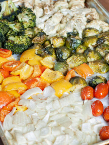 Roasted vegetables on a sheet pan with parchment paper.