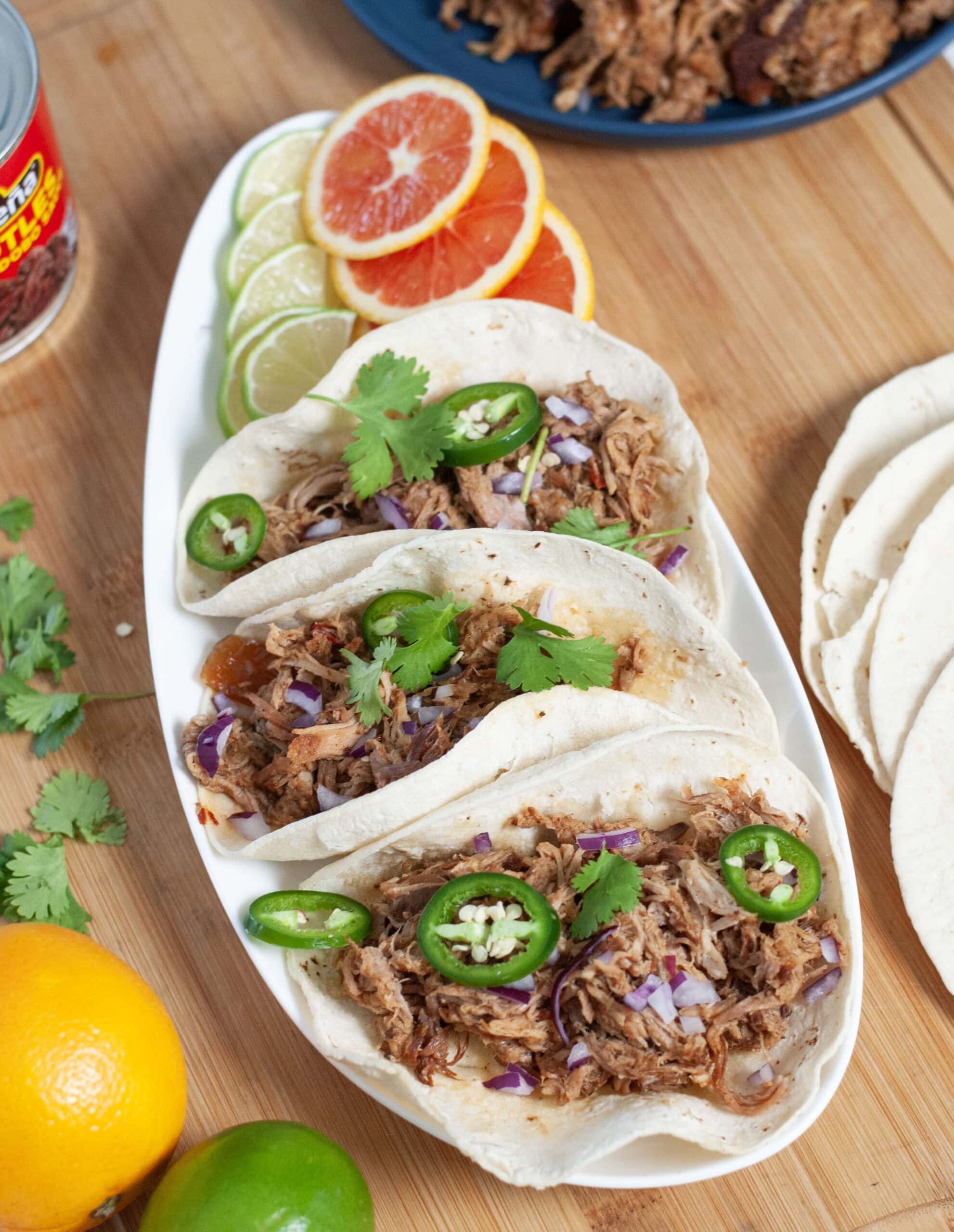 Pulled pork on tacos with cilantro and jalapeño.
