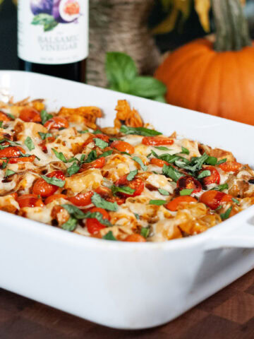 A casserole topped with tomatoes and basil.