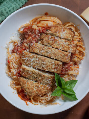 Chicken Parmesan with noodles and basil.