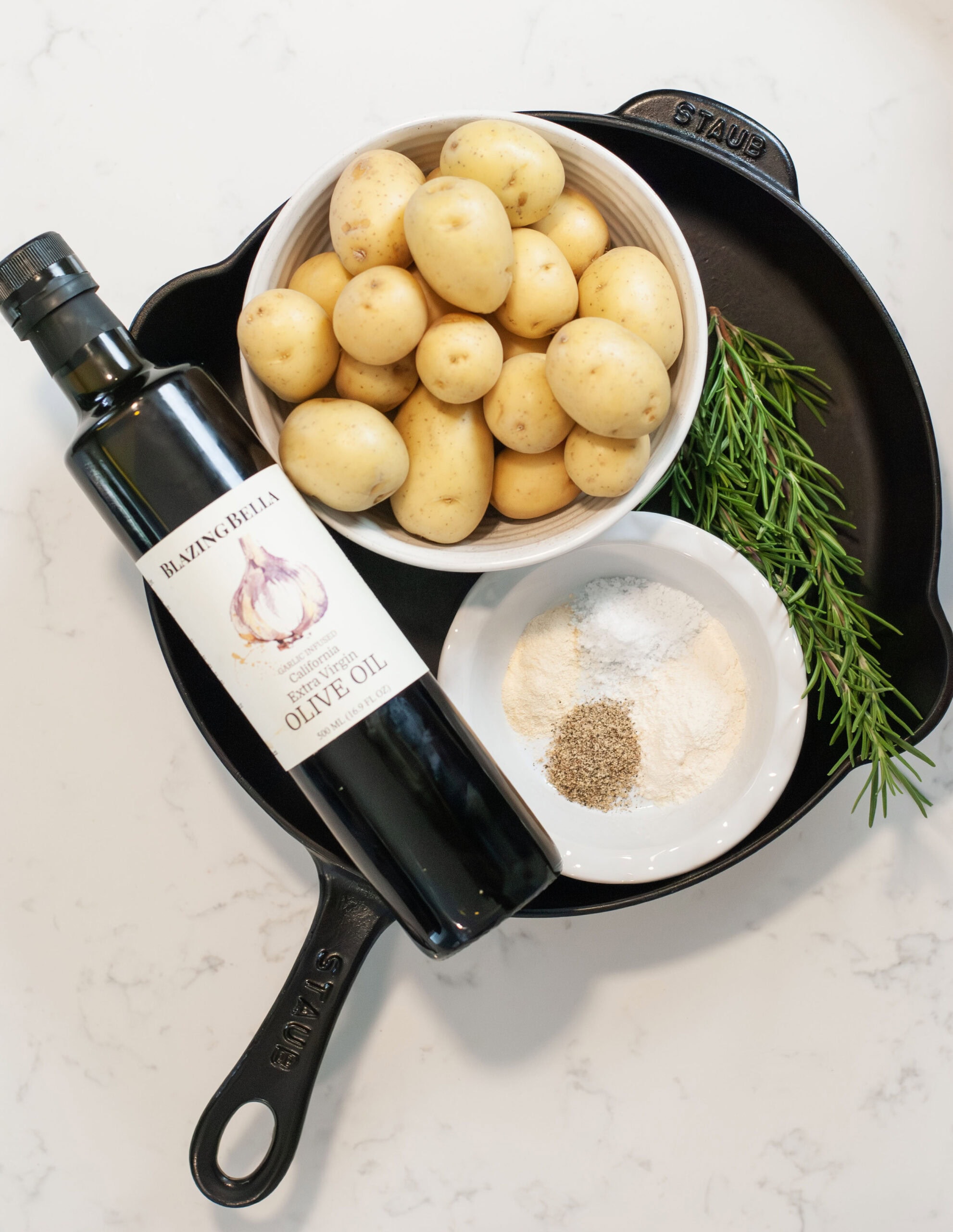 Ingredients for rosemary potatoes in a skillet.